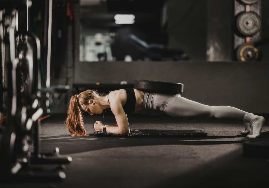 Imagem mostra mulher realizando prancha abdominal
